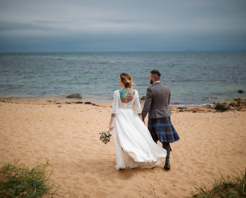 Bride and Groom on the beach at Ruby Bay next to the Lady's Tower in Elie, Fife on their wedding day.